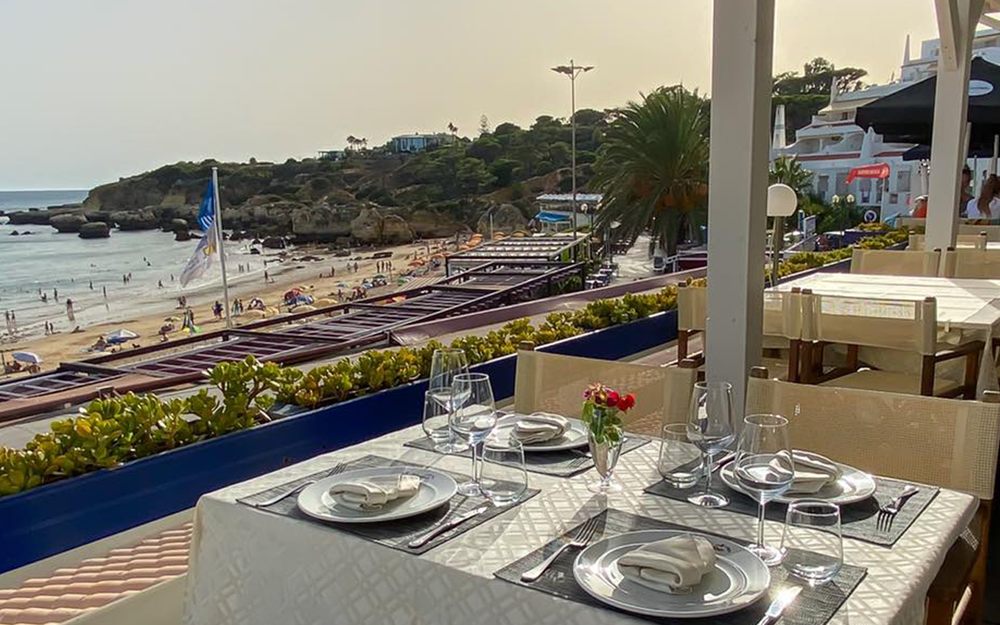 Mesa posta na esplanada da Oura com vista para a praia e as falésias